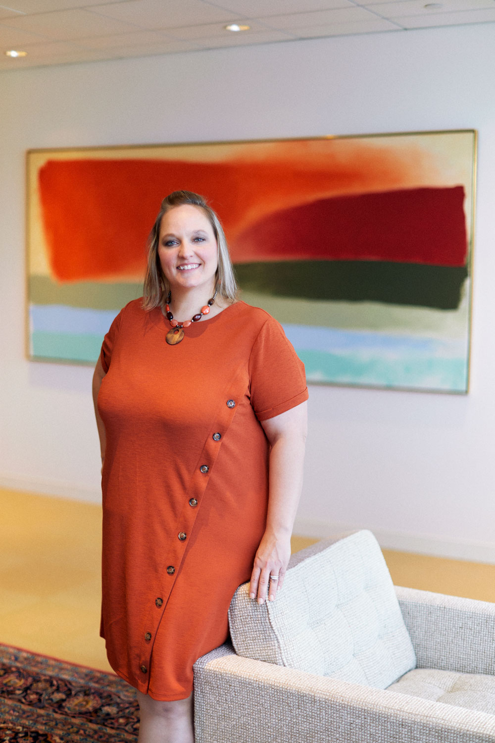 Brinn stands in front of “Red Crossing” by Friedel Dzubas which hangs in the second floor lobby of Central Bank’s Financial Center.
