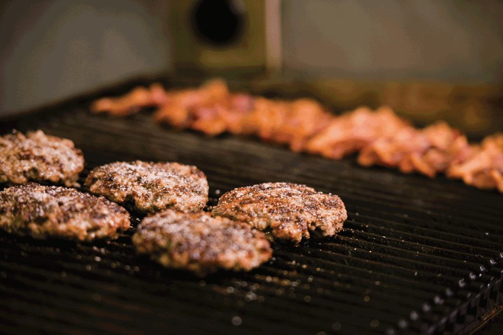 Burgers and bacon on the grill.